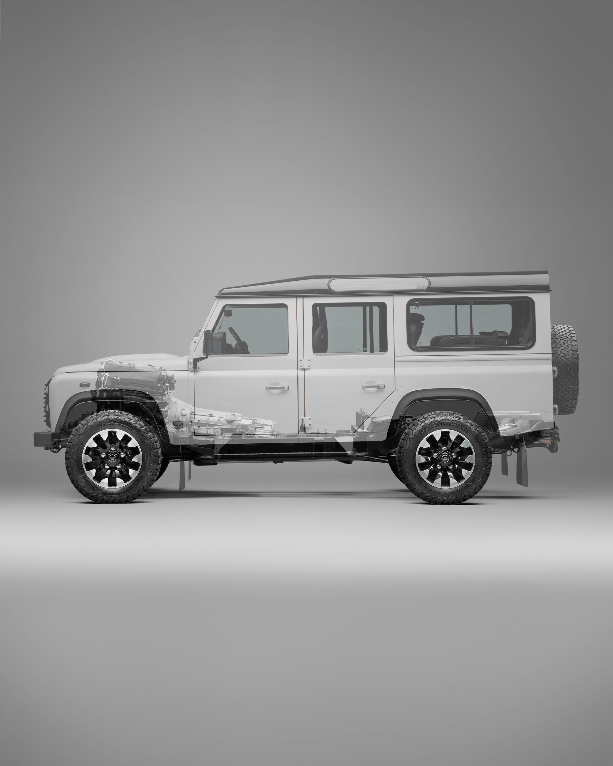 Front view of a black Defender with visible grille, headlights, and side mirror.
