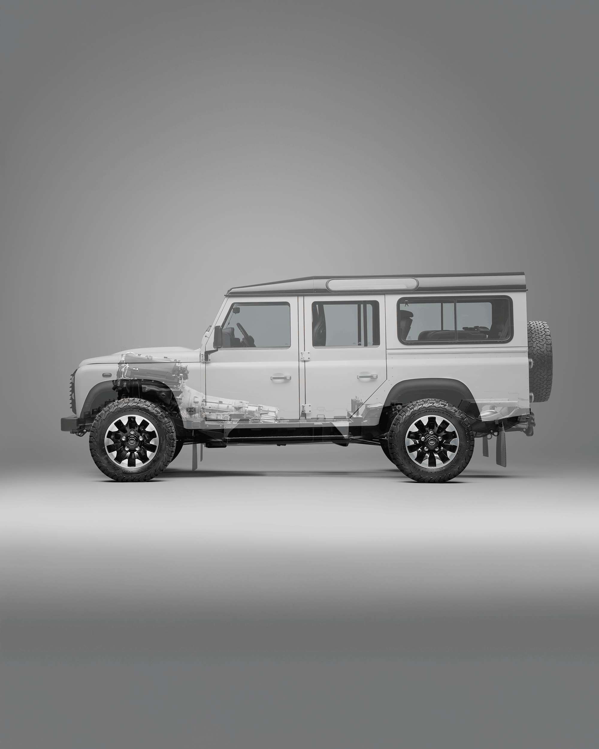 Front view of a black Defender with visible grille, headlights, and side mirror.