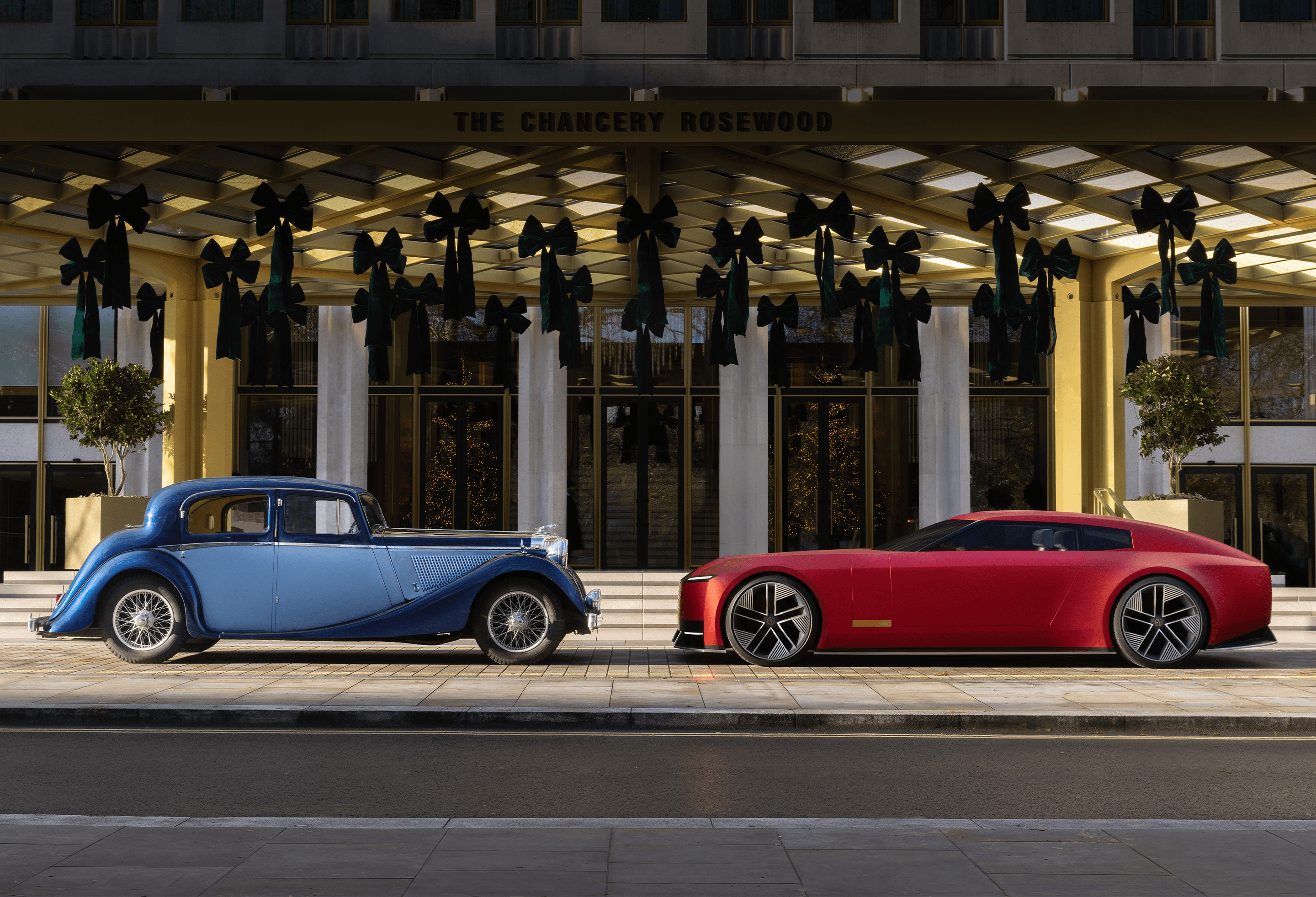 Front right tire of a black Defender in a shadowed concrete setting.